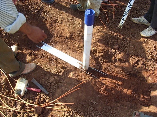 Magnetic Extensometer with cross-arm anchor being installed in dam core construction